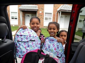 Windsor-built Dodge Grand Caravan and Chrysler Town and County minivans filled with dozens of backpacks and school supplies easily caught the attention of St. Joseph's Community children Dnaya Muise, 10, left, and Elisha Back, 9, and others during a wrap-up event for United Way Summer Lunch program Thursday August 27, 2015. The Summer Lunch program provides healthy meal for children who rely on school nutrition programs.  The Back To School Supply Drive and Summer Lunch programs had several sponsors including FCA Windsor Assembly Plant, Staples on Ouellette Ave., CAW Local 444, Farrow, Caesars Windsor, Harvey Strosberg,  Sutts, Strosberg LLP, Bart Seguin at Shibley Righton LLP, Unemployed Help Centre, Hotel-Dieu Grace Healthcare, Windsor Essex Community Housing Corp. and both school boards. (NICK BRANCACCIO/The Windsor Star)