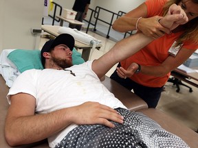 David Younan works with a physiotherapist at Hotel-Dieu Grace Hospital in Windsor on Wednesday, August 12, 2015.                        (TYLER BROWNBRIDGE/The Windsor Star)