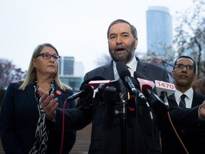 In this file photo, NDP Leader Tom Mulcair, centre, is flanked by former provincial court judges NDP candidates Carol Baird Ellan, left, (Burnaby North-Seymour) and Bill Sundhu (Kamloops-Thompson-Cariboo) as he comments on Bill C-51 and Canada's mission against ISIS during a media availability at Robson Square in Vancouver, B.C., on Thursday, March 19, 2015. THE CANADIAN PRESS/Darryl Dyck