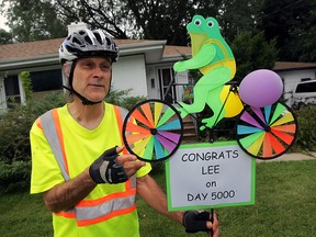 Lee Amlin admires a congratulatory lawn ornament after he completed 5,000 daily bicycle rides, Sept. 9, 2015.   Amlin has hopped on his bicycle each day and toured the city and county, through rain and snow.  (NICK BRANCACCIO/The Windsor Star)