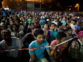 Syrian refugees wait at the port of Lesbos island, Greece, to board a ferry travelling to Athens, on Monday, Sept. 7, 2015. An immigration expert says recent announcements of provincial support for Syrian refugees fail to address the question of who would foot the bill to sponsor more immigrants from the war-ravaged country. THE CANADIAN PRESS/AP/Petros Giannakouris