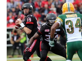 Quarterback Bo Levi Mitchell has running back Tory Harrison holding off Eskimos safety Ryan Hinds as the Calgary Stampeders played host to the Edmonton Eskimos for the Labour Day Classic on September 7, 2015 at McMahon Stadium. (Lorraine Hjalte/Postmedia News)