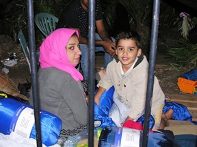 A family from Iraq who survived from a wreck sit outside the local coast guard office at Lakki port on the southeastern Greek island of Leros, Sunday, Sept. 13, 2015. At least 34 people seeking a better life in Europe drowned early Sunday as they attempted a wind-swept crossing from Turkey to Greece, a journey often made more dangerous because smugglers require asylum seekers to pilot the overloaded craft themselves in choppy seas.