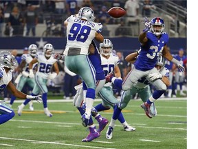 New York Giants' Shane Vereen pitches the ball against Dallas Cowboys' Tyrone Crawford on the last play of the game at AT&T Stadium on September 13, 2015 in Arlington, Texas.