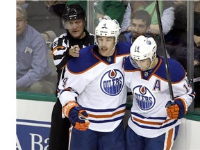 Referee Brad Watson (23) signals a goal scored by Edmonton Oilers' Taylor Hall (4) as Hall celebrates the score with Jordan Eberle (14) in the third period of an NHL hockey game against the Dallas Stars, Tuesday, Nov. 25, 2014, in Dallas. The Stars won the game, 3-2. (Tony Gutierrez/Postmedia News)