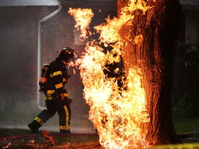 A Windsor firefighters walks near a natural gas fire on Belleperche Place in Windsor following a lightning strike. Windsor fire sprayed water on a nearby home while waiting for Union Gas to arrive. (JASON KRYK/The Windsor Star)