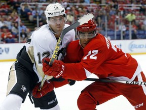 Pittsburgh Penguins center Kevin Porter (12) and Detroit Red Wings center Andreas Athanasiou (72) battle for position in the second period of a preseason NHL hockey game in Detroit on Thursday, Sept. 24, 2015. (AP Photo/Paul Sancya)