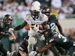 Windsor's Arjen Colquhoun, right, and Riley Bullough tackle Oregon's Royce Freema during the fourth quarter of an NCAA college football game, Saturday, Sept. 12, 2015, in East Lansing, Mich. Michigan State won 31-28. (AP Photo/Al Goldis)