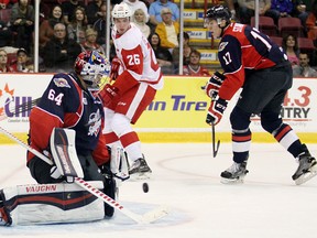 Windsor Spitfires goaltender Michael DiPietro, left, make a save as Spitfires defenceman Logan Stanley, right, and Soo Greyhounds forward Tim Gettinger look on during first-period action Friday, Sept. 25, 2015 at Essar Centre in Sault Ste. Marie, Ont. (JEFFREY OUGLER/Sault Star)