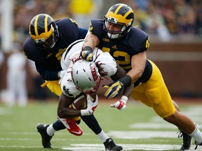 Channing Stribling #8 of the Michigan Wolverines and teammate Ben Gedeon #42 tackle Devonte Boyd #83 of the UNLV Rebels on September 19, 2015 at Michigan Stadium in Ann Arbor, Michigan.  (Photo by Gregory Shamus/Getty Images)