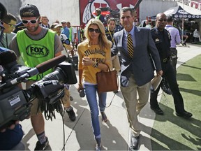 Michigan coach Jim Harbaugh and his wife, Sarah Harbaugh, arrive before for Michigan's NCAA college football game against Utah on Thursday, Sept. 3, 2015, in Salt Lake City. (AP Photo/Rick Bowmer)