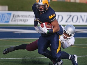 Windsor's Beau Lumley tries to escape a tackle by Ottawa's Jackson Bennett during the OUA football quarter-final between the Windsor Lancers and the Ottawa Gee Gees at Alumni Field, Saturday, Nov.1, 2014.  Windsor lost to Ottawa 46-29.  (DAX MELMER/The Windsor Star)