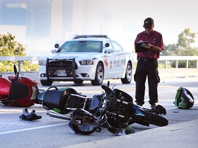 An investigator from Ontario's Special Investigations Unit investigates a serious accident on Riverside Dr. W. involving two motorcycles on Wednesday, Sept. 23, 2015. (DAN JANISSE/The Windsor Star)