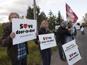 Canada Post postal service workers attend a protest to save door-to-door mail service before a Conservative members event in Oshawa on Oct. 9, 2014.