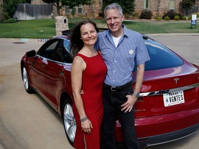 Mark Peters, right, and his wife Elizabeth Farrell Peters pose for a photo by their leather-free Tesla Model S, in Hurst, Texas. The Peters, Tesla Motors shareholders, had a simple request for the electric car maker at its annual meeting in June: Stop offering leather interiors and make Tesla the first “cruelty-free” premium brand. (AP Tony Gutierrez)