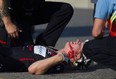 A cyclist lays on the ground after crashing into a traffic sign at the roundabout corner at Erie St. and Parent Ave. during the Pro Race at the Tour di via Italia, Sunday, Sept. 6, 2015.   The cyclist was taken to hospital with unknown injuries.  (DAX MELMER/The Windsor Star)