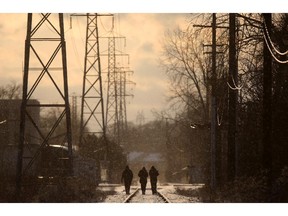 WINDSOR, ONT.:JANUARY 29, 2012 -- Three people walk westward along the railroad tracks between Sunset Avenue and Huron Line in what was a wild weather day of snow and sunshine, Sunday, Jan. 29, 2012.  (DAX MELMER / The Windsor Star)