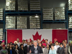 Surrounded by racks of food, Conservative leader Stephen Harper speaks about the Syrian refugee crisis during a campaign event in Surrey, B.C., Thursday September 3, 2015.. THE CANADIAN PRESS/Adrian Wyld