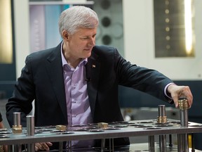 Conservative leader Stephen Harper puts an ejector guide bushing on a mold that casts car parts while campaigning in Windsor, on Sunday, September 20, 2015. (THE CANADIAN PRESS/Ryan Remiorz)