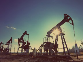 Working oil pumps silhouette against sun - vintage retro style. Image by fotolia.com