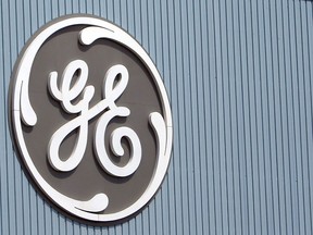 In this Tuesday, June 24, 2014 file photo, the General Electric logo is seen at a plant in Belfort, eastern France. The European Union on Tuesday, Sept. 8, 2015 has approved General Electric's $14.1 billion takeover of the power and transmission division of French company Alstom, pending the sale of key parts of Alstom's heavy duty gas turbines business.