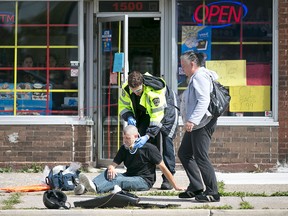 EMS Paramedics tend to a man after he was struck by an SUV while riding his eBike at the intersection of Parent Avenue and Shepherd Street East, Sunday, Sept. 20, 2015.  The rider of the eBike was taken to hospital with unknown injuries. (DAX MELMER/The Windsor Star)