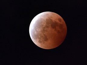For the first time in decades, skygazers are in for the double spectacle on Sept. 28, 2015 of a swollen "supermoon" bathed in the blood-red light of a total eclipse.  (AFP PHOTO / Yoshikazu TSUNO)