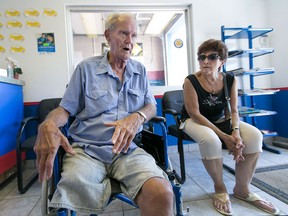 John Sinclair, left, who is struggling to pay for his prosthetic leg, sits next to his wife Amelia Cathy Sinclair, while attending a car-wash fundraiser in his honour at Cowell Auto, Sunday, Sept. 6, 2015.  (DAX MELMER/The Windsor Star)