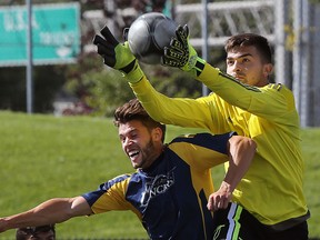 Windsor' Michael Pio (L) collides with Laurier goalkeeper Jovan Brudiu during their game on Sunday, Sept. 13, 2015, at the Alumni Field in Windsor.  (DAN JANISSE/The Windsor Star)