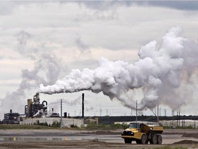 FILE -- A dump truck works near the Syncrude oil sands extraction facility near the town of Fort McMurray, Alberta on Sunday June 1, 2014. The furore over a New Democrat candidate's remarks about leaving a lot of Alberta's oilsands in the ground is a reflection of how poorly the issue is understood, say energy experts.