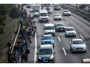 Migrants and refugees walk towards Edirne on September 21, 2015 in Istanbul. A new march by migrants trying to reach Europe overland from Turkey was blocked by police outside Istanbul today. Around 700 mostly Syrian men, women and children from a group that had been blocked for the past week at Istanbul's main bus station set out overnight on footfor the northwestern city of Edirne, 250 kilometres (150 miles) away.