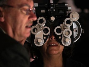An optometrist checks a patient's eyes in this file photo.