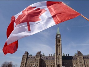 A Canadian flag attached to a ski pole is waved on Parliament Hill in Ottawa on Monday, April 15, 2013.
