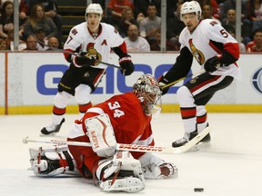Detroit Red Wings goalie Petr Mrazek (34) stops an Ottawa Senators shot as Kyle Turris (7) and Cody Ceci (5) look on in the first period of an NHL hockey game in Detroit Tuesday, March 31, 2015. (AP Photo/Paul Sancya)
