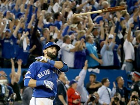 Jose Bautista #19 of the Toronto Blue Jays throws his bat up in the air after he hits a three-run home run in the seventh inning against the Texas Rangers in game five of the American League Division Series at Rogers Centre on October 14, 2015 in Toronto, Canada.  (Photo by Tom Szczerbowski/Getty Images)