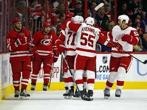 Detroit Red Wings' Niklas Kronwall (55) and Jonathan Ericsson (52) congratulate teammate Dylan Larkin (71) on his goal as Carolina Hurricanes' Kris Versteeg (32) and Justin Faulk (27) skate by during the second period of an NHL hockey game, Saturday, Oct. 10, 2015, in Raleigh, N.C. Detroit won 4-3. (AP Photo/Karl B DeBlaker)