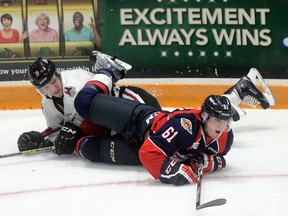 Windsor's Luke Boka, right, checks Guelph's Kyle Rhodes during the Spitfires' 2-1 win at the Sleeman Centre Friday. (Tony Saxon, Mercury staff)