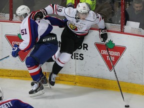 Owen Sound Attack Kyle Platzer slips past Windsor Spitfires Jalen Chatfield in OHL action at WFCU Centre Thursday February 5, 2015. (NICK BRANCACCIO/The Windsor Star)