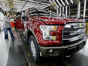 In this March 13, 2015 file photo, a worker inspects a new 2015 aluminum-alloy body Ford F-150 truck at the company's Kansas City Assembly Plant in Claycomo, Mo. The Commerce Department releases its August report on durable goods on Thursday, Sept. 24, 2015.