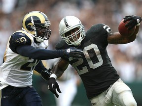 Darren McFadden #20 of the Oakland Raiders runs against Oshiomogho Atogwe #21 of the St. Louis Rams during an NFL game at Oakland-Alameda County Coliseum on September 19, 2010 in Oakland, California
