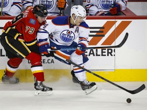 Ex-Spitfire Taylor Hall, right, gets past Calgary Flames' Michael Ferland (79) during third period NHL hockey action in Calgary on Saturday, Oct. 17, 2015. THE CANADIAN PRESS/Jeff McIntosh