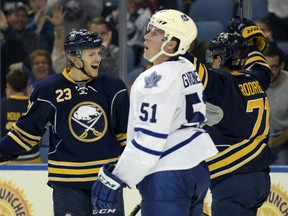 Toronto Maple Leafs' Jake Gardiner (51) reacts as Buffalo Sabres' Sam Reinhart (23) celebrates with Evan Rodrigues (71) after Rodrigues scored during the third period of an NHL preseason hockey game, Tuesday, Sept. 29, 2015 in Buffalo, N.Y. Buffalo won 4-0. (AP Photo/Gary Wiepert)