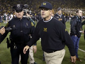 Michigan head coach Jim Harbaugh walks off the field after their 27-23 loss to Michigan State in an NCAA college football game, Saturday, Oct. 17, 2015, in Ann Arbor, Mich. (AP Photo/Carlos Osorio)