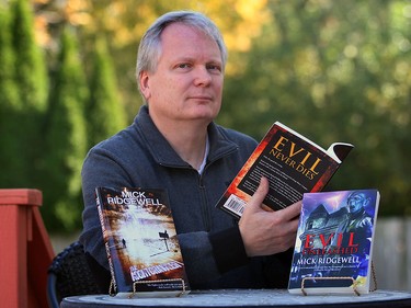 Author Mick Ridgewell holds his latest novel, Evil Never Dies Oct. 22, 2015.