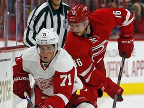 Carolina Hurricanes' Elias Lindholm (16) of Sweden strips the puck away from Detroit Red Wings' Dylan Larkin (71) during the first period of an NHL hockey game, Saturday, Oct. 10, 2015, in Raleigh, N.C. (AP Photo/Karl B DeBlaker)