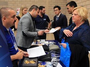Job seeker Shirley Harshaw, right, speaks with Marc Charron, left, of Windsor Machine Group at Windsor-Essex Job Day held WFCU Centre Friday October 23, 2015. The annual event attracted hundreds over the course of the day with many local companies ready to hire new employees.  Windsor Machine Group where looking for about 15 new hires to fill a variety of positions.