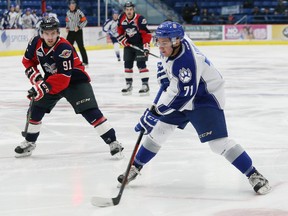 David Levin, right, of the Sudbury Wolves, prepares to pass the puck to a teammate as Aaron Luchuk, of the Windsor Spitfires, attempts to poke the puck away during OHL action at the Sudbury Community Arena in Sudbury, Ont. on Friday October 23, 2015. John Lappa/Sudbury Star/Postmedia Network