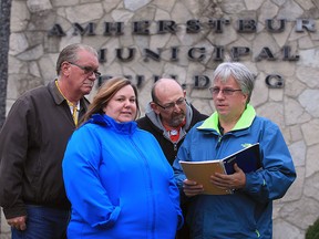 Sarah Gibb, centre, Larry Amlin, left, Auggie Menna and Marc Renaud are frustrated they have to wait in the town hall vestibule while Amherstburg council are in-camera October 29, 2015. In photo, the group take note the date of the next council meeting.