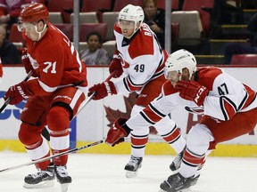 Former Spitfire Michal Jordan, right, tries to steal the puck from Detroit's Dylan Larkin while Victor Rask follows the play in Detroit Oct. 16, 2015. (AP Photo/Duane Burleson)