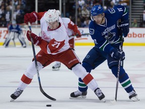 Detroit Red Wings' Dylan Larkin, left, takes the puck away from Vancouver Canucks' Radim Vrbata, of the Czech Republic, during the first period of an NHL hockey game in Vancouver, B.C., on Saturday October 24, 2015. THE CANADIAN PRESS/Darryl Dyck
